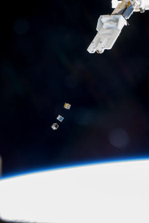 Cubesats deployed from Small Satellite Orbital Deployer attached to Kibo laboratory robotic arm (NASA photo) - RF Cafe