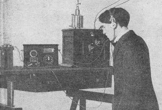 Frank Butler stands in front of the equipment which made the first phone broadcast - RF Cafe
